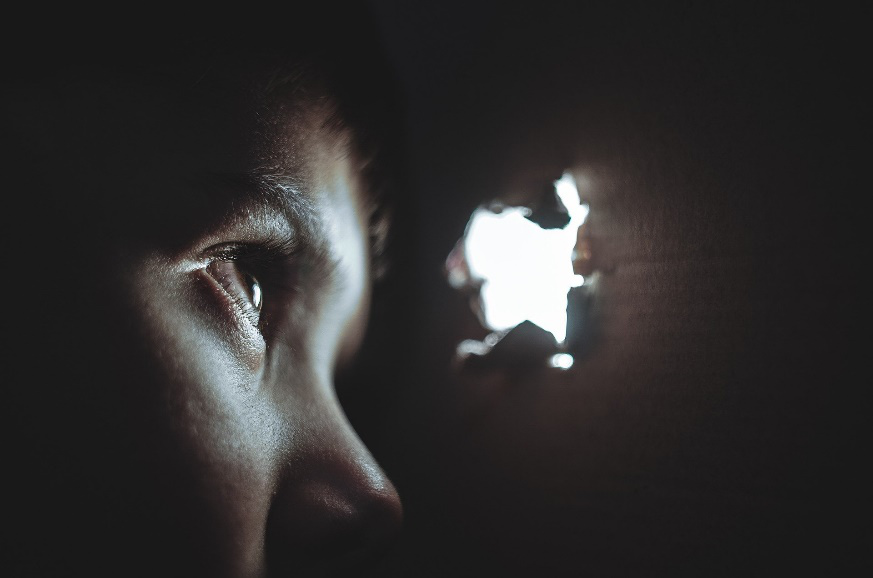 A child hiding in a box with a hole in it