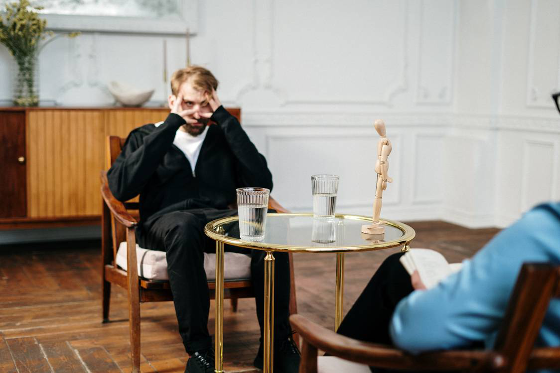 A man expressing frustration through body language in a mental health therapy session.