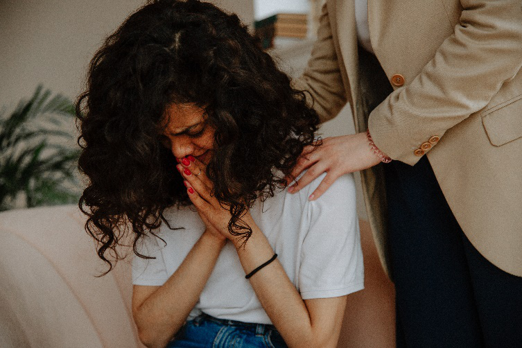 A worried woman being comforted by another person