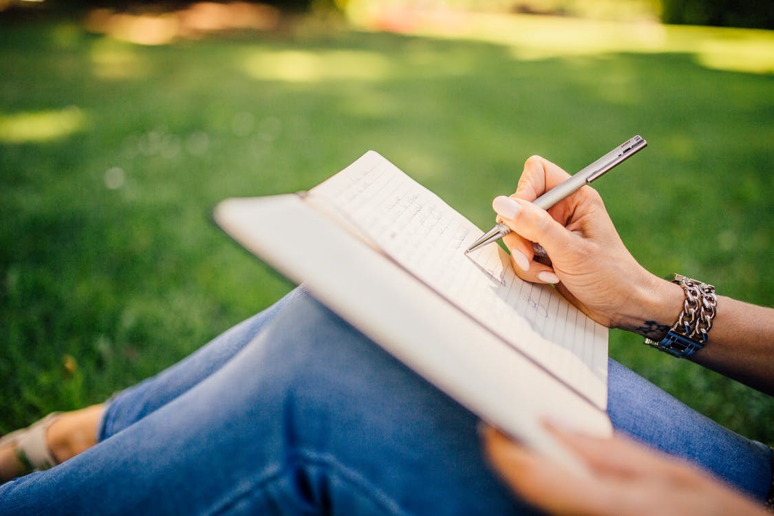 woman writing her thoughts in a journal