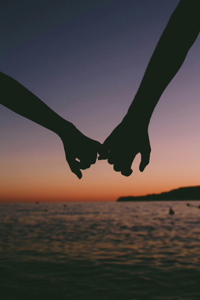 a couple holding pinkies