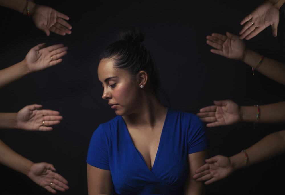 A woman surrounded by hands before getting anxiety counseling in Barrow County