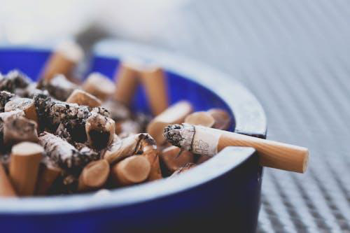  Burning cigarette in an ashtray, symbolizing addiction and the need for mental health support in overcoming substance use.